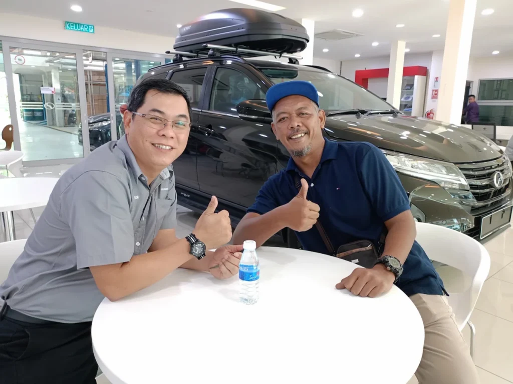 JE YEW bersama pelanggan Perodua di bilik pameran